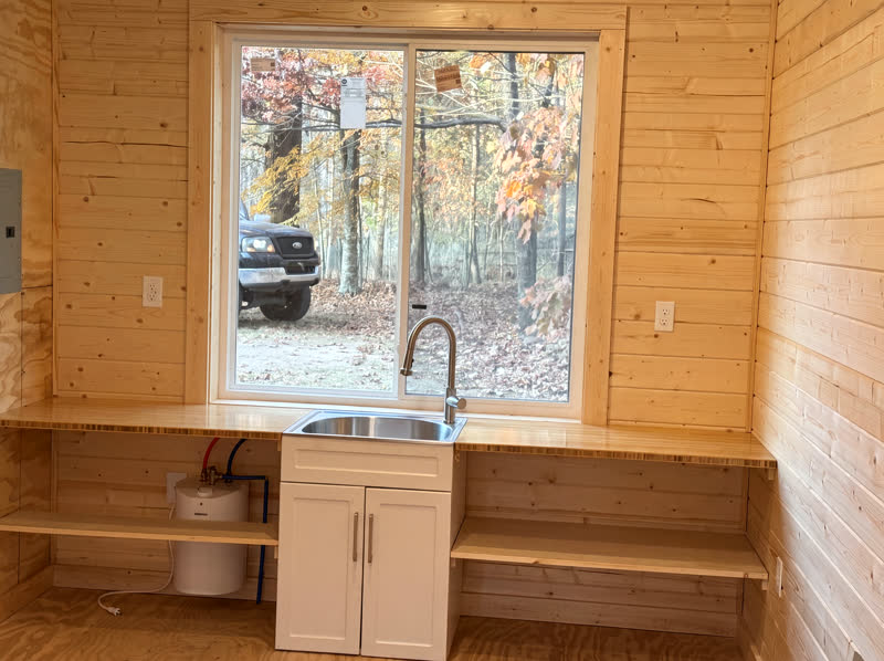Custom pine cabin with board-and-batten siding and white french doors in the Cumberland Plateau woods