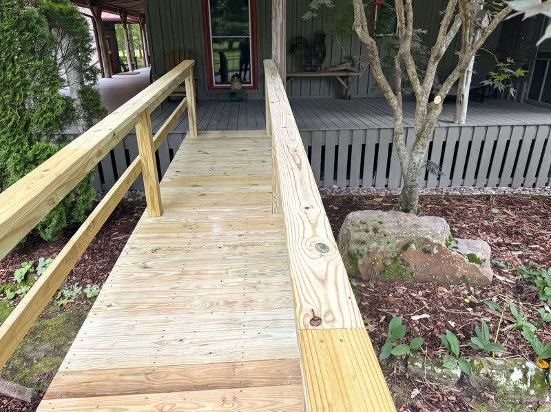 Custom wood wheelchair accessibility ramp with handrails at a Cumberland Plateau mountain home